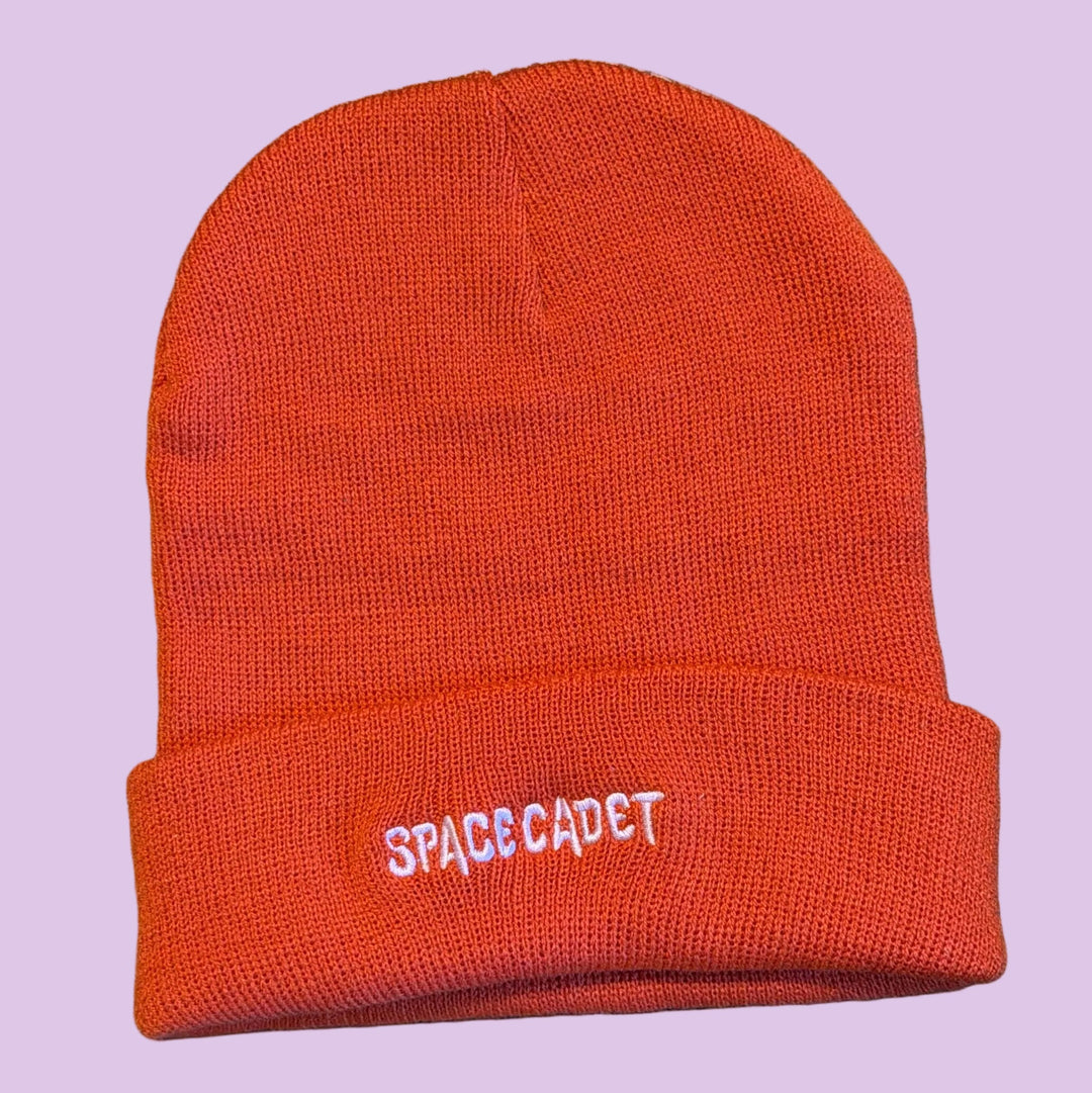 beanie hat with emboridered text that reads 'space cadet' in pink thread