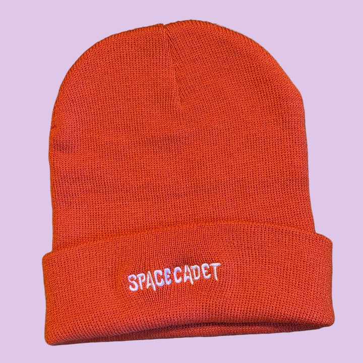 beanie hat with emboridered text that reads 'space cadet' in pink thread